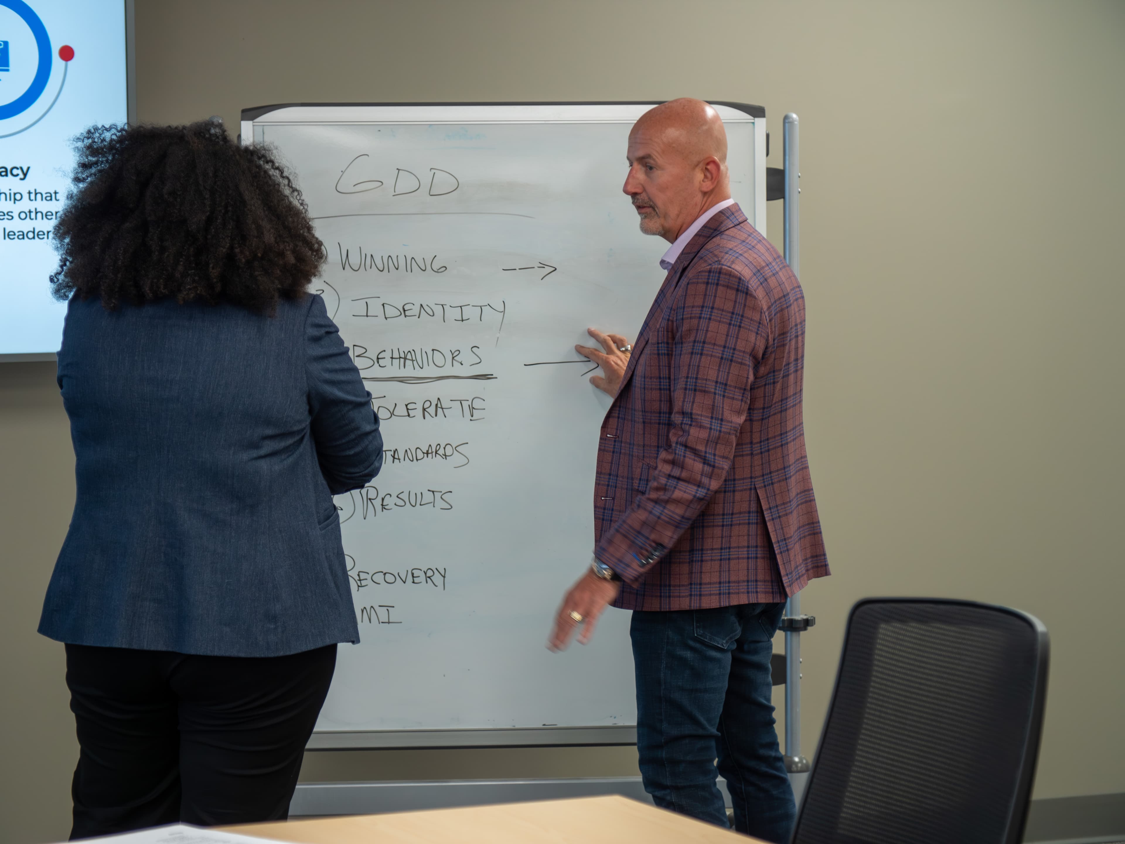 Steve Lowisz coaching a leader through the GDD framework at a whiteboard
